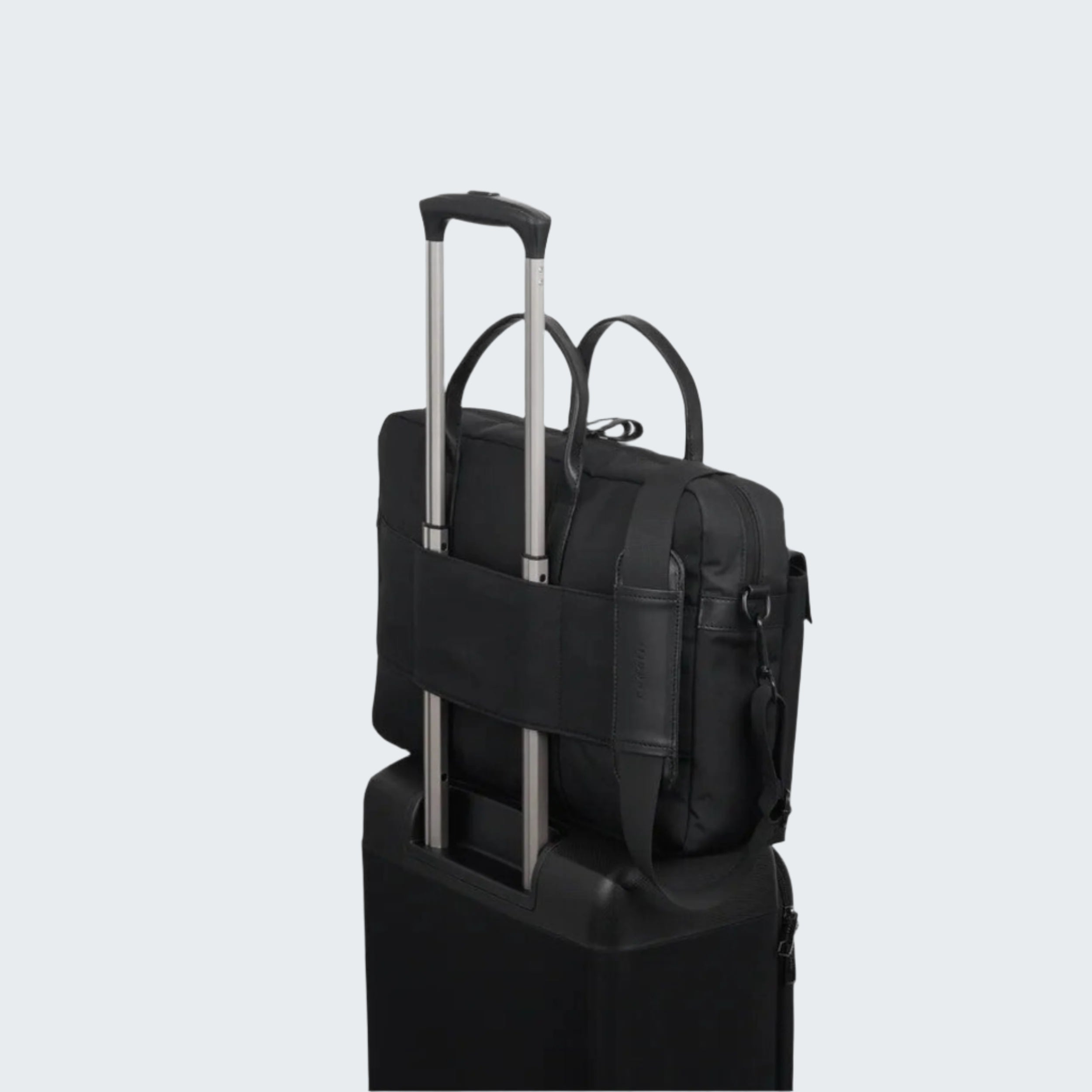 Black backpack with rolling handle attached to a suitcase on a white background