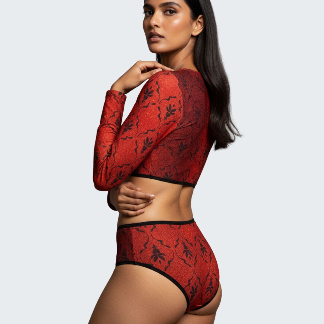 Woman wearing a red lace lingerie set against a gray background