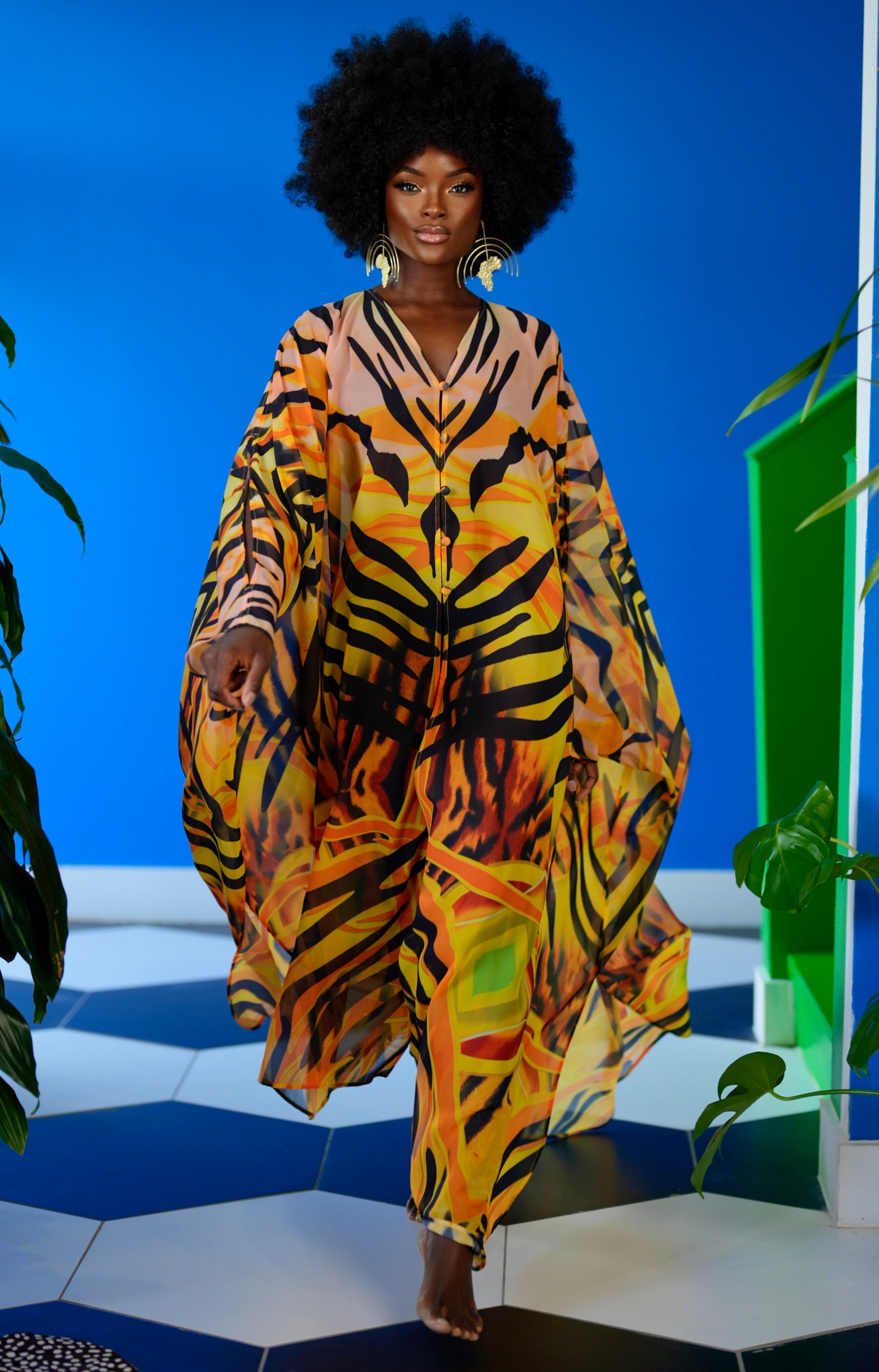 Model wearing a colorful tiger print outfit on a blue and green geometric background