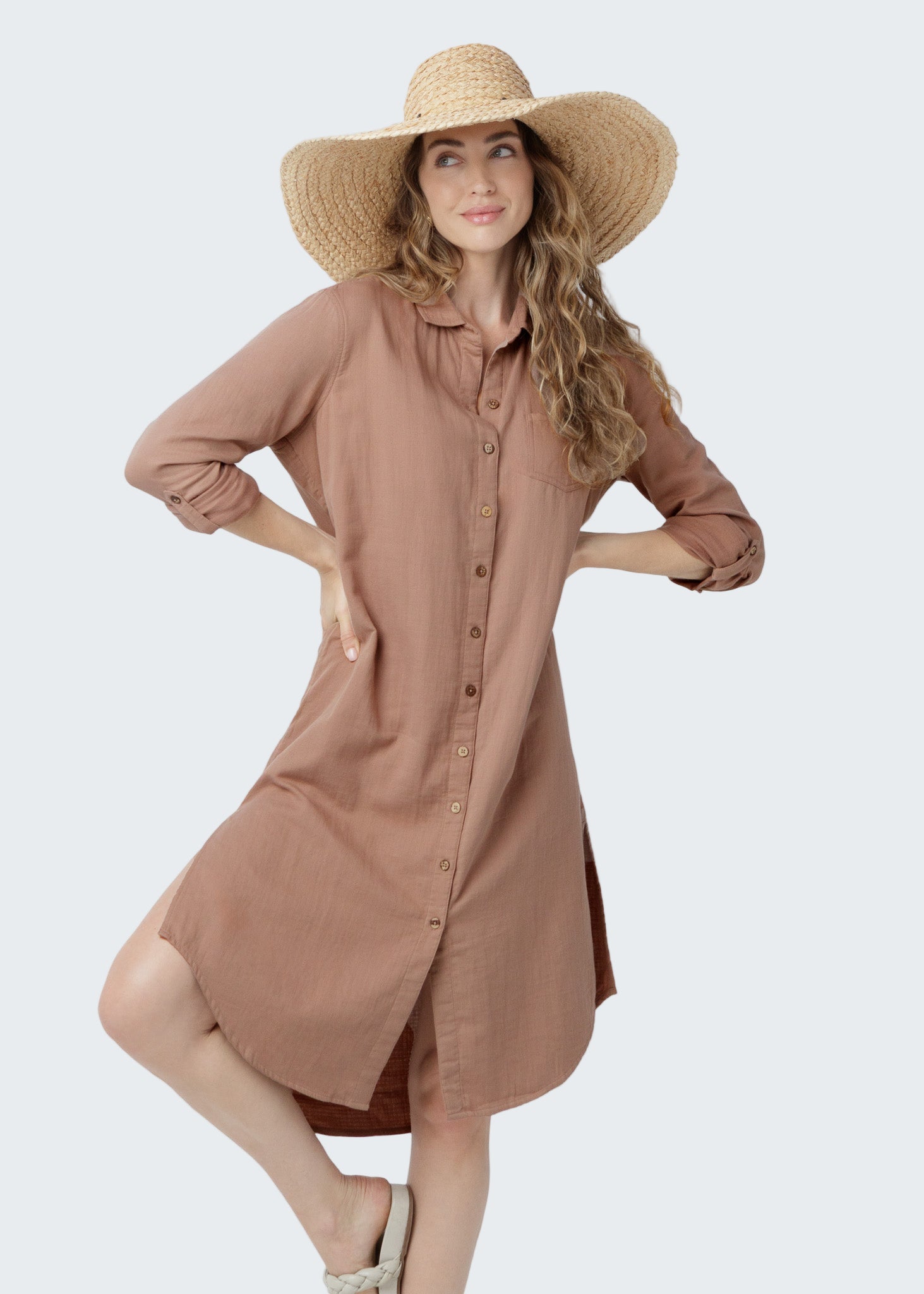 Woman wearing a brown dress and wide-brimmed hat on a white background