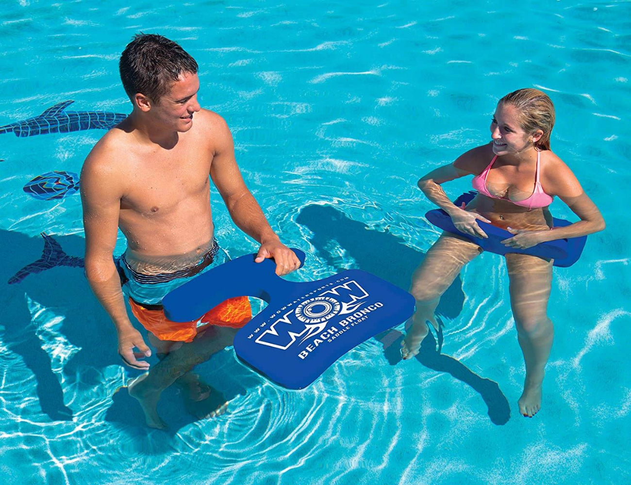 Two people using blue swimboards in a pool with 'Beach Body' branding.
