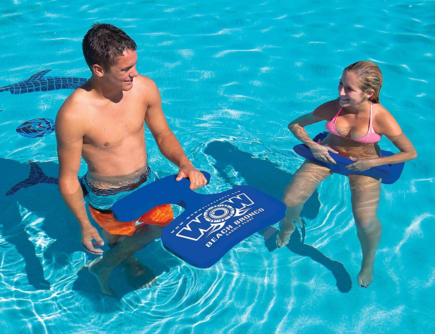 Two people using blue swimboards in a pool with 'Beach Body' branding.