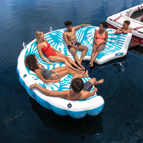 Group of people relaxing on a circular inflatable island in the water.