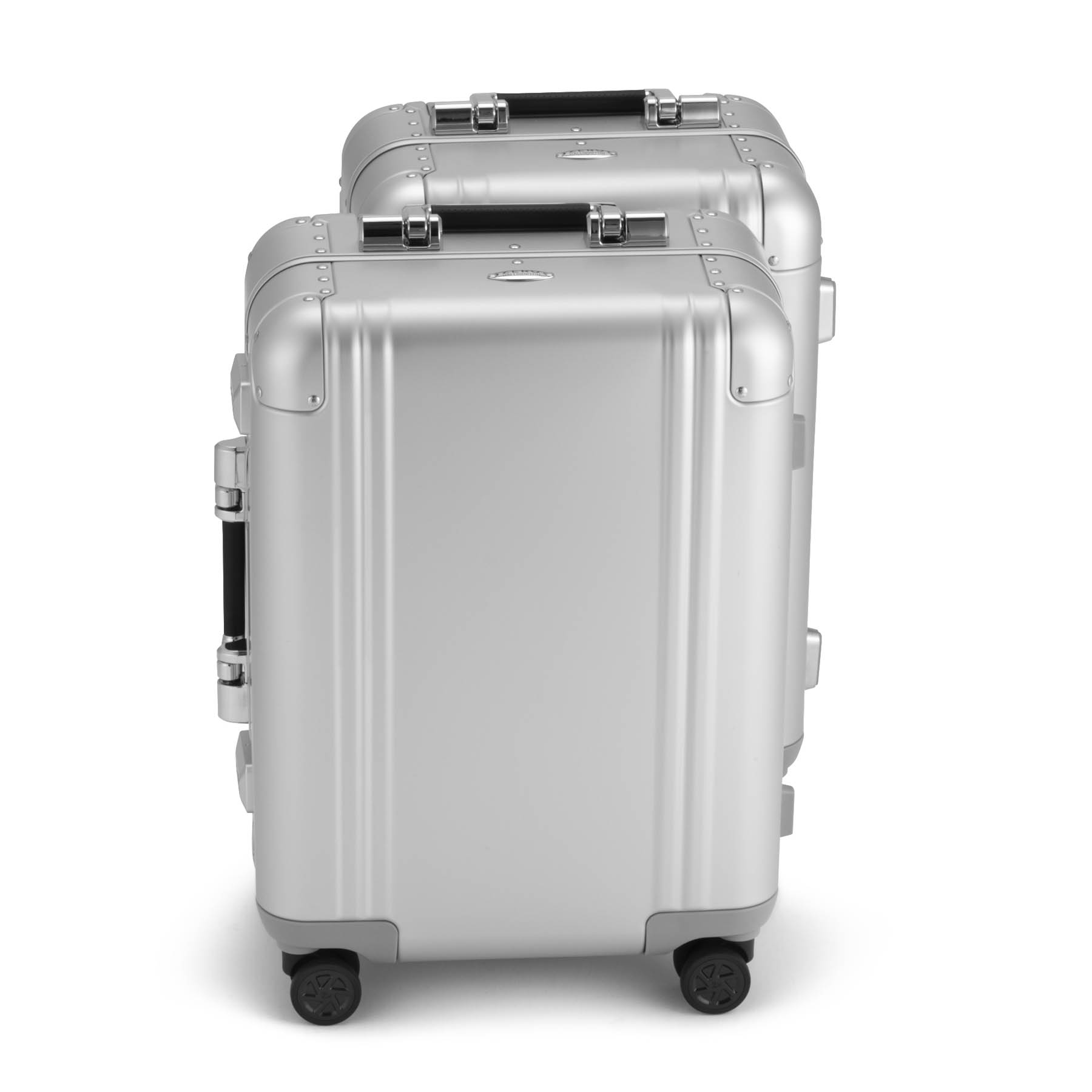 Two silver suitcases stacked on a white background