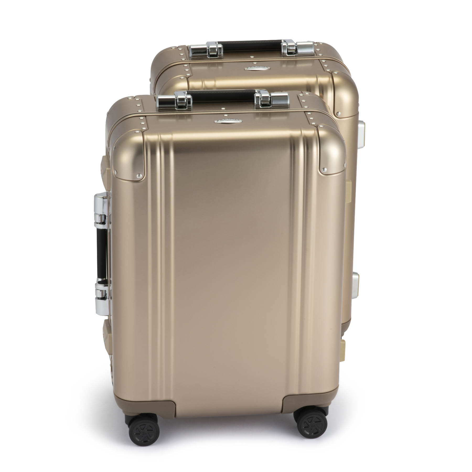 Two gold suitcases stacked on a white background