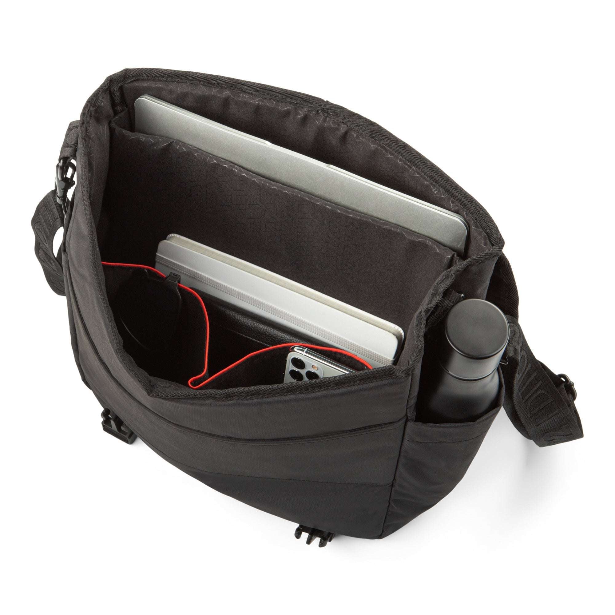 Black crossbody bag with compartments containing a laptop, phone, and other items on a white background