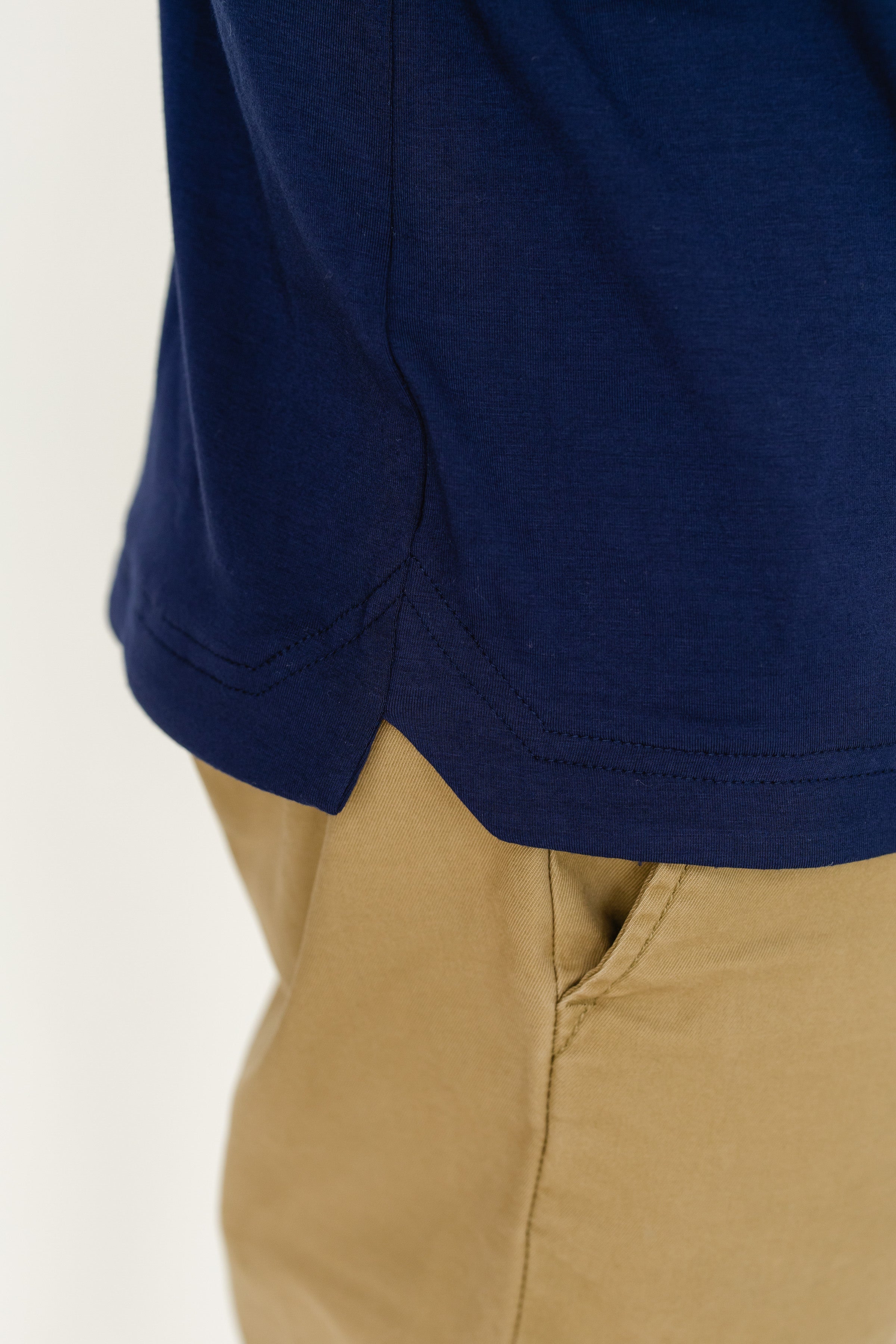 Navy blue t-shirt and beige pants on a white background