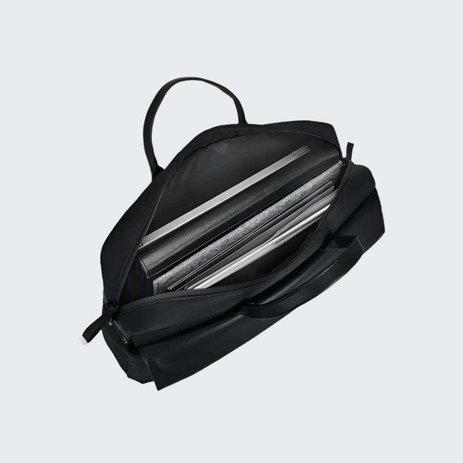 Black backpack with a compartment open, showing a silver laptop inside on a white background