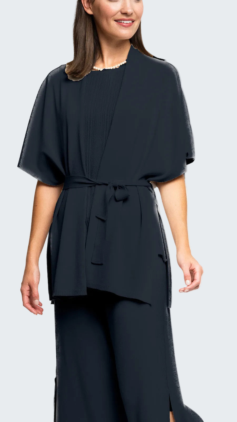 Woman wearing a navy blue dress with a belt on a white background