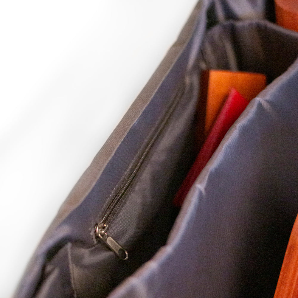 Close-up of a gray bag with colorful items inside on a white background