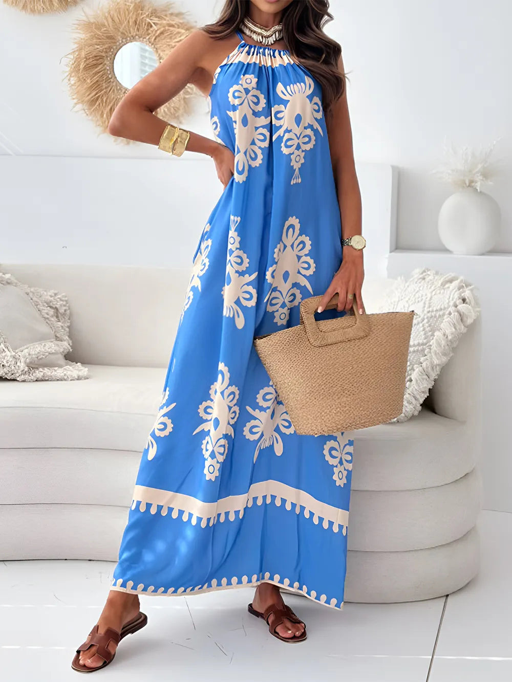A woman wearing a white and black printed spaghetti strap sleeveless maxi dress with a sheer neckline.