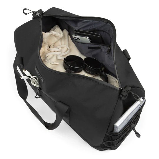 Black duffel bag with compartments containing items on a white background