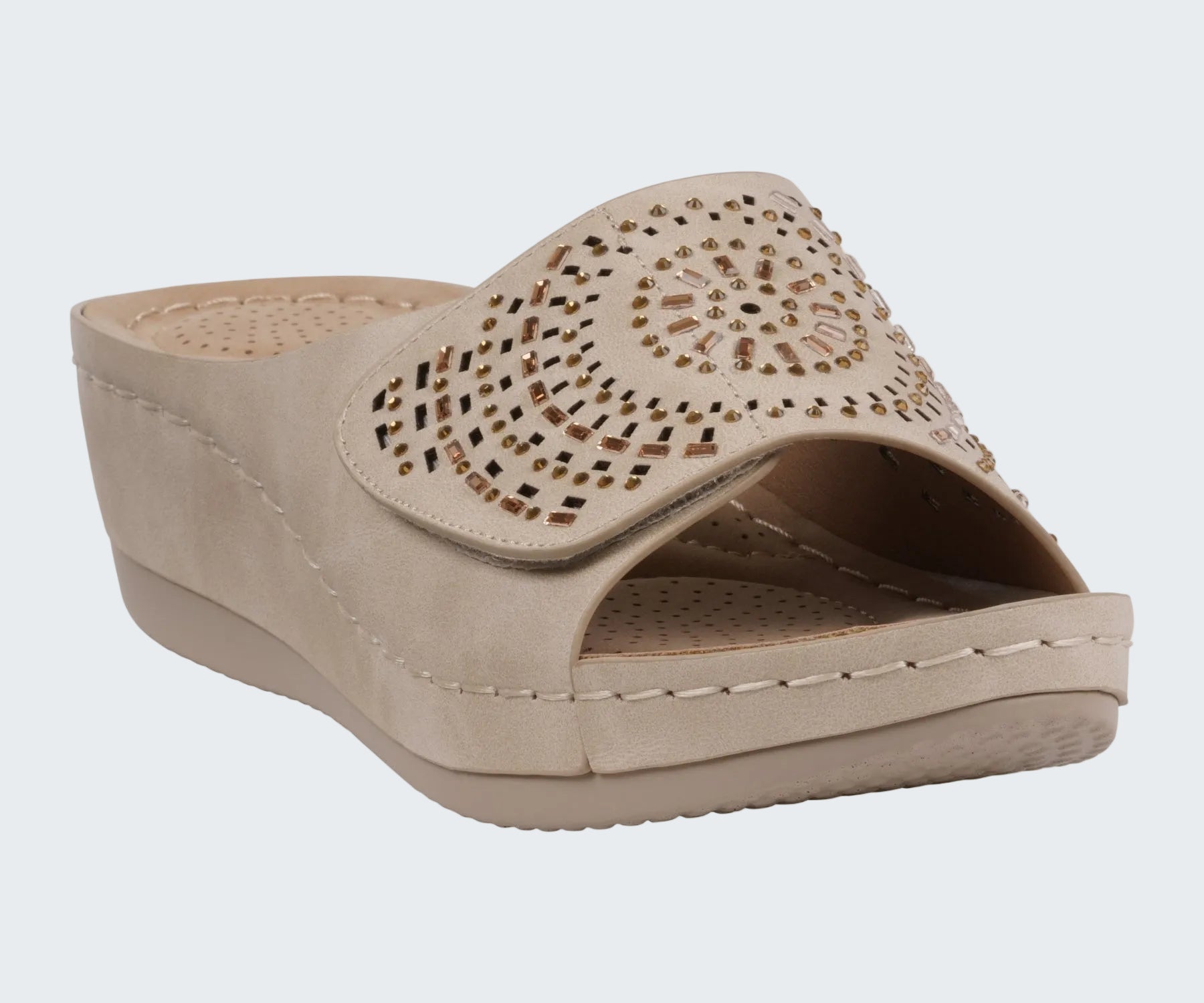 Beige wedge sandal with decorative cut-out design on a white background