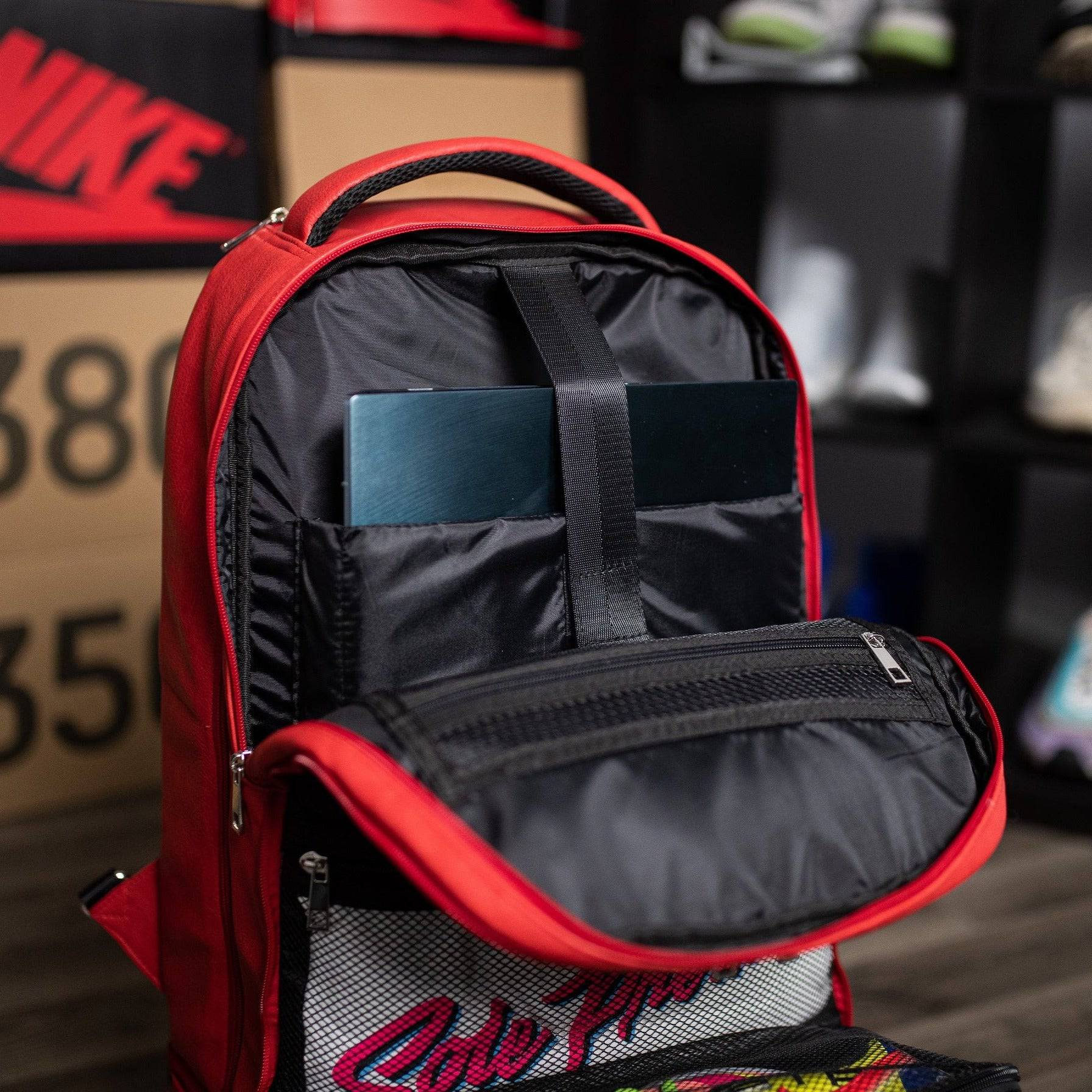 Red backpack with black interior, placed on a surface with blurred background