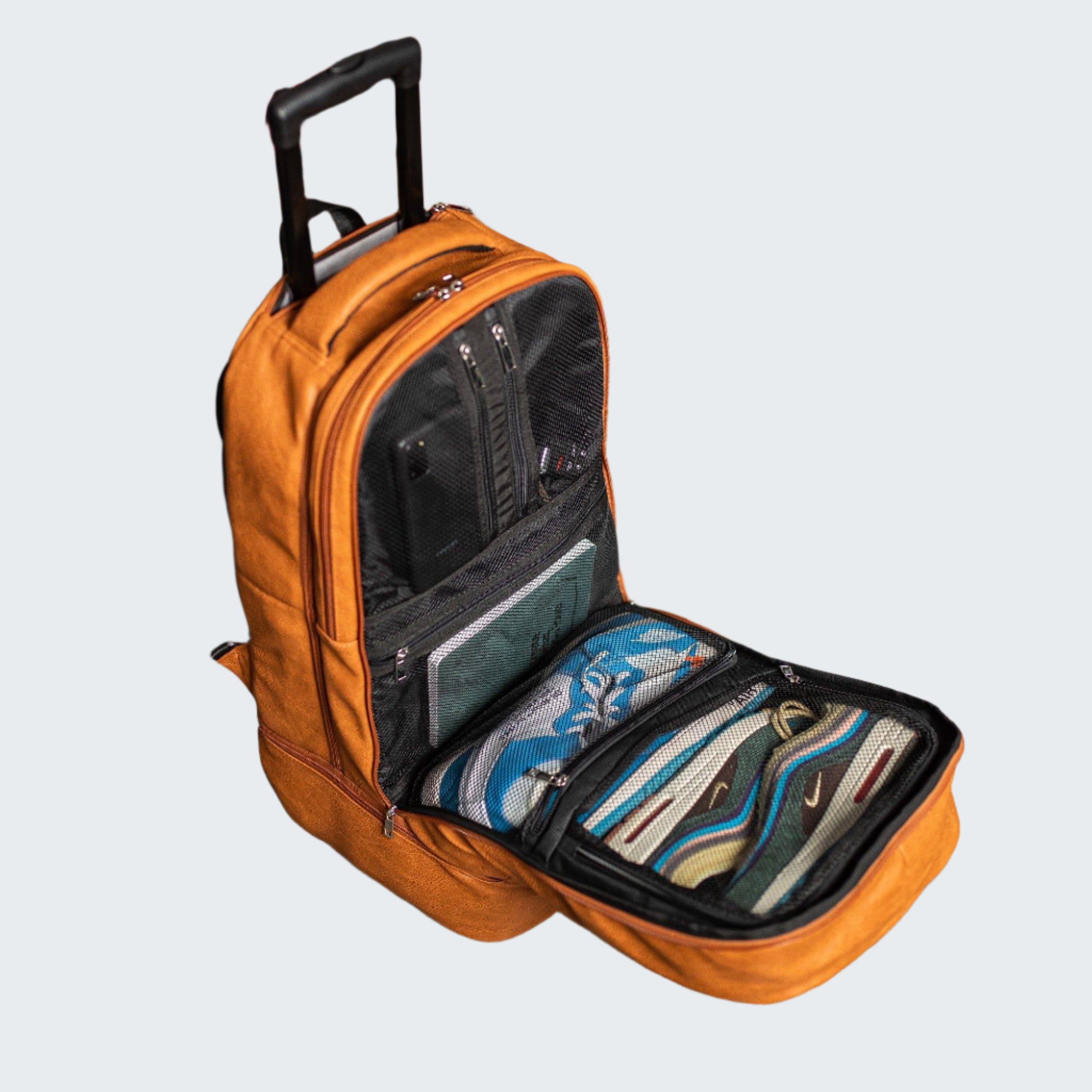 Orange backpack with shoes inside on a wooden floor, with boxes and shoes in the background.