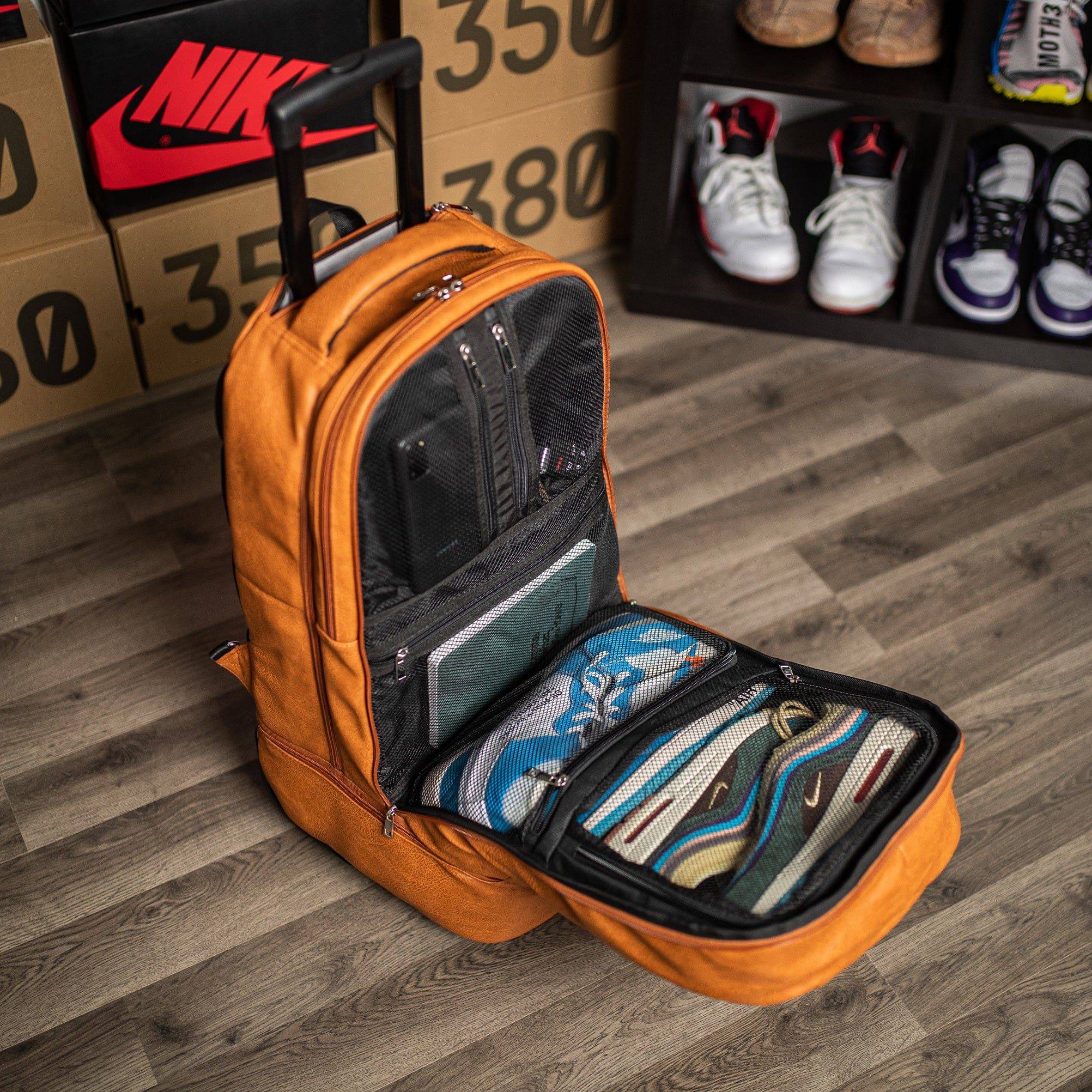Orange backpack with shoes inside on a wooden floor, with boxes and shoes in the background.