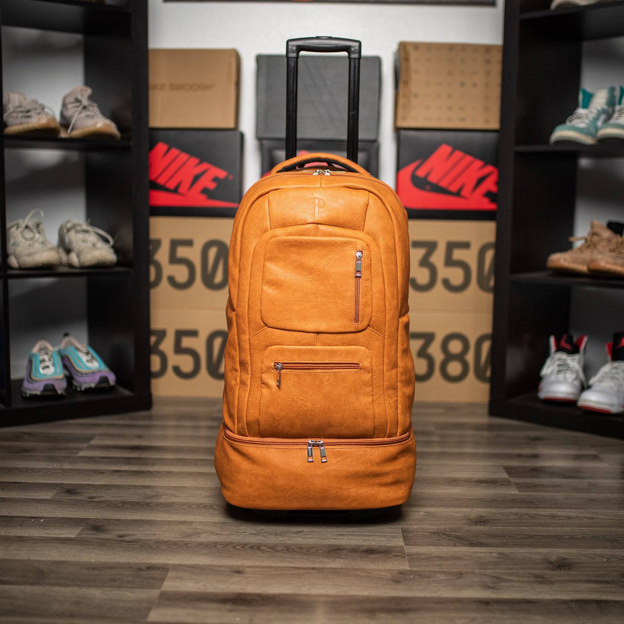 Orange backpack with wheels on a wooden floor with shelves displaying shoes and Nike boxes in the background.