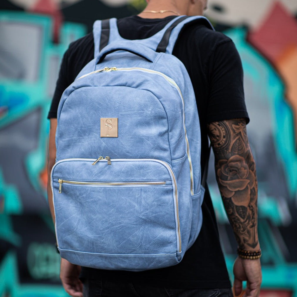 Person wearing a blue backpack with a blurred background
