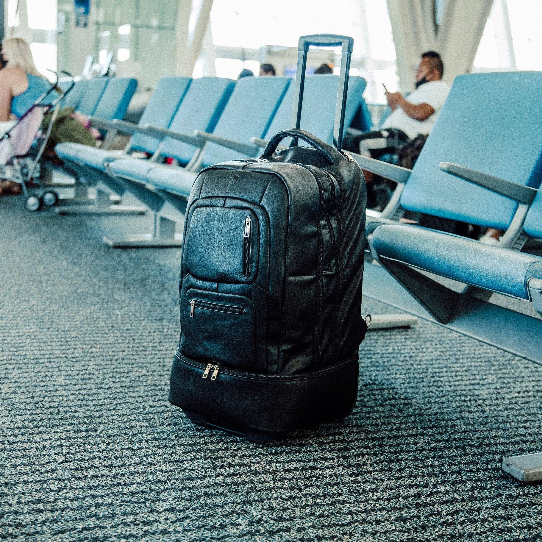 Black backpack on a blue carpeted floor with chairs and people in the background