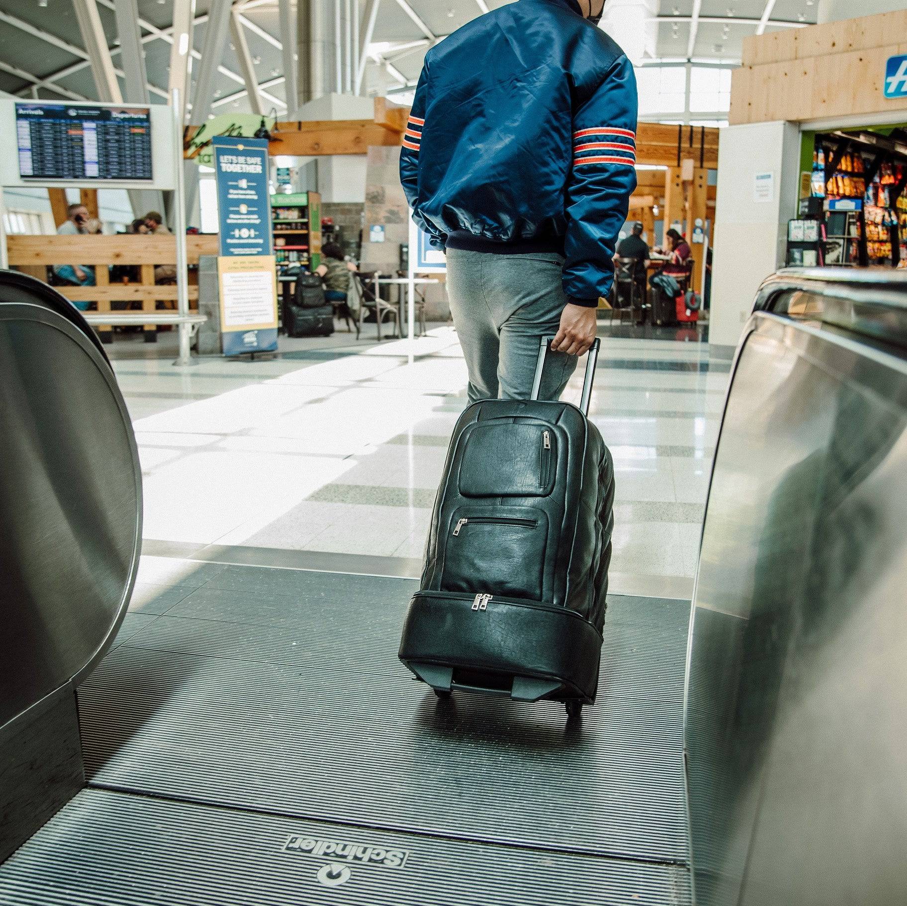 Person with a suitcase walking on an escalator in an airport terminal