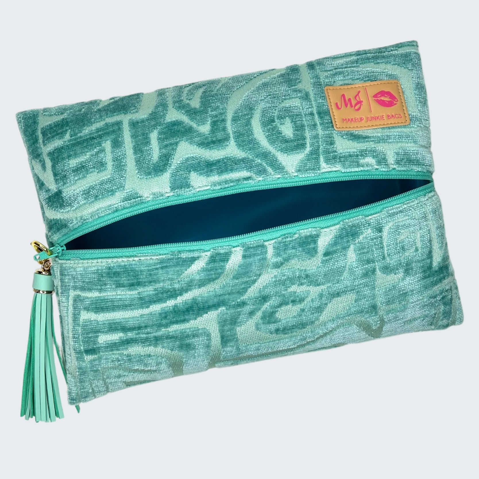 Teal patterned pouch with a tassel on a white background