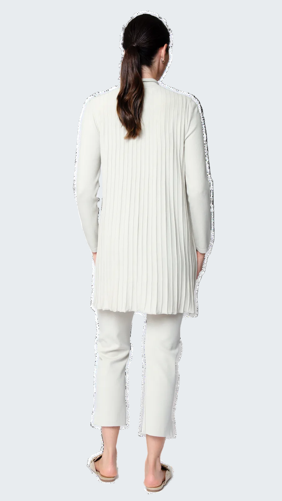 Woman wearing a white pleated jacket and pants on a white background