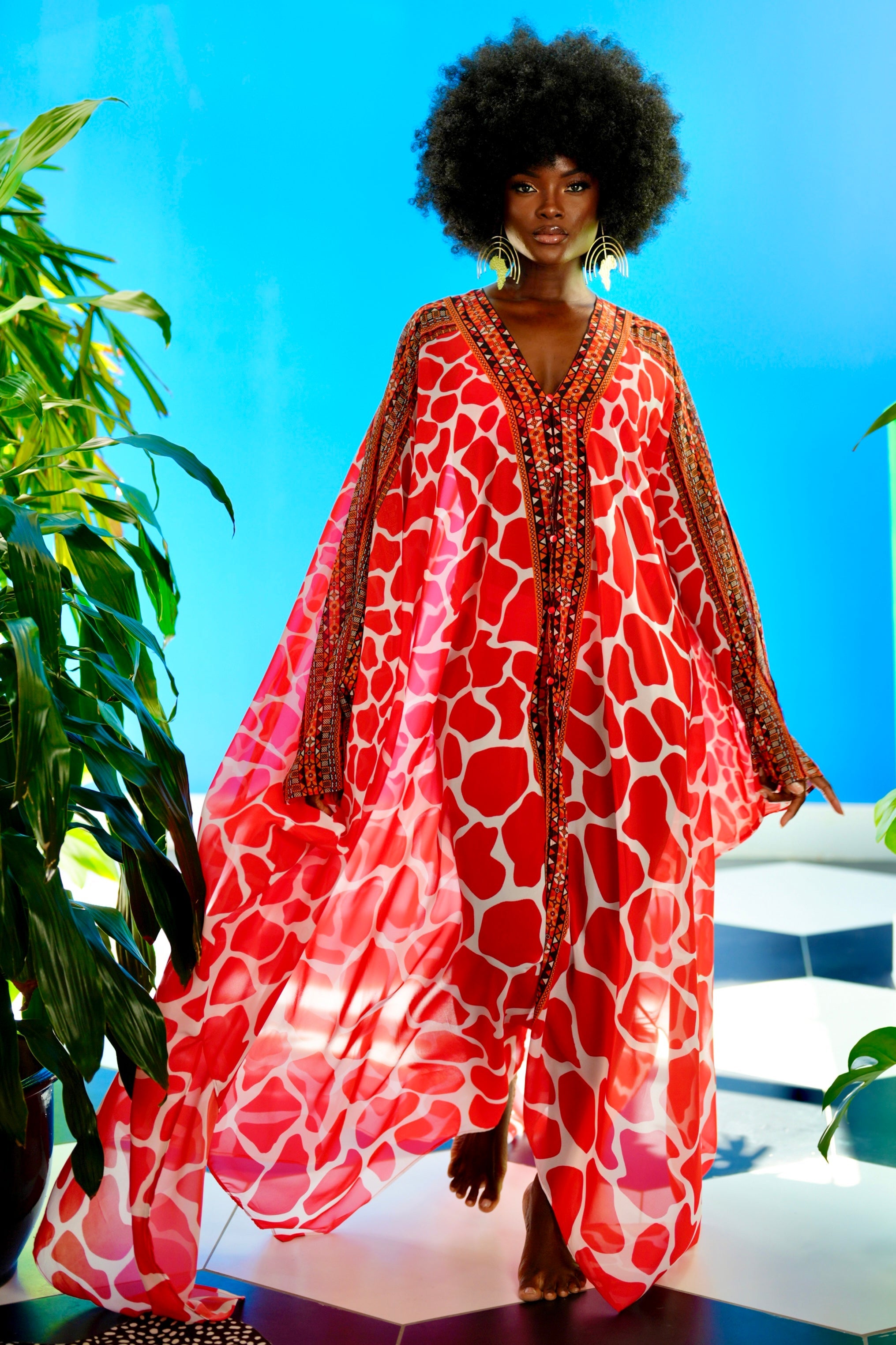 Woman wearing a red patterned dress against a blue sky