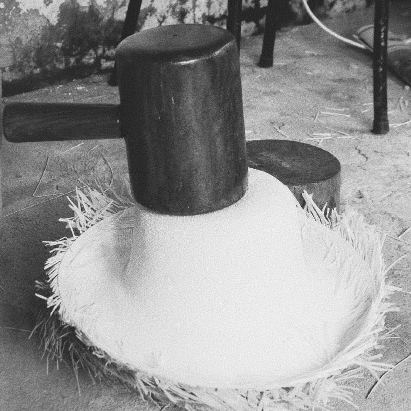 Close-up of a wooden mallet on a straw hat with a blurred outdoor background