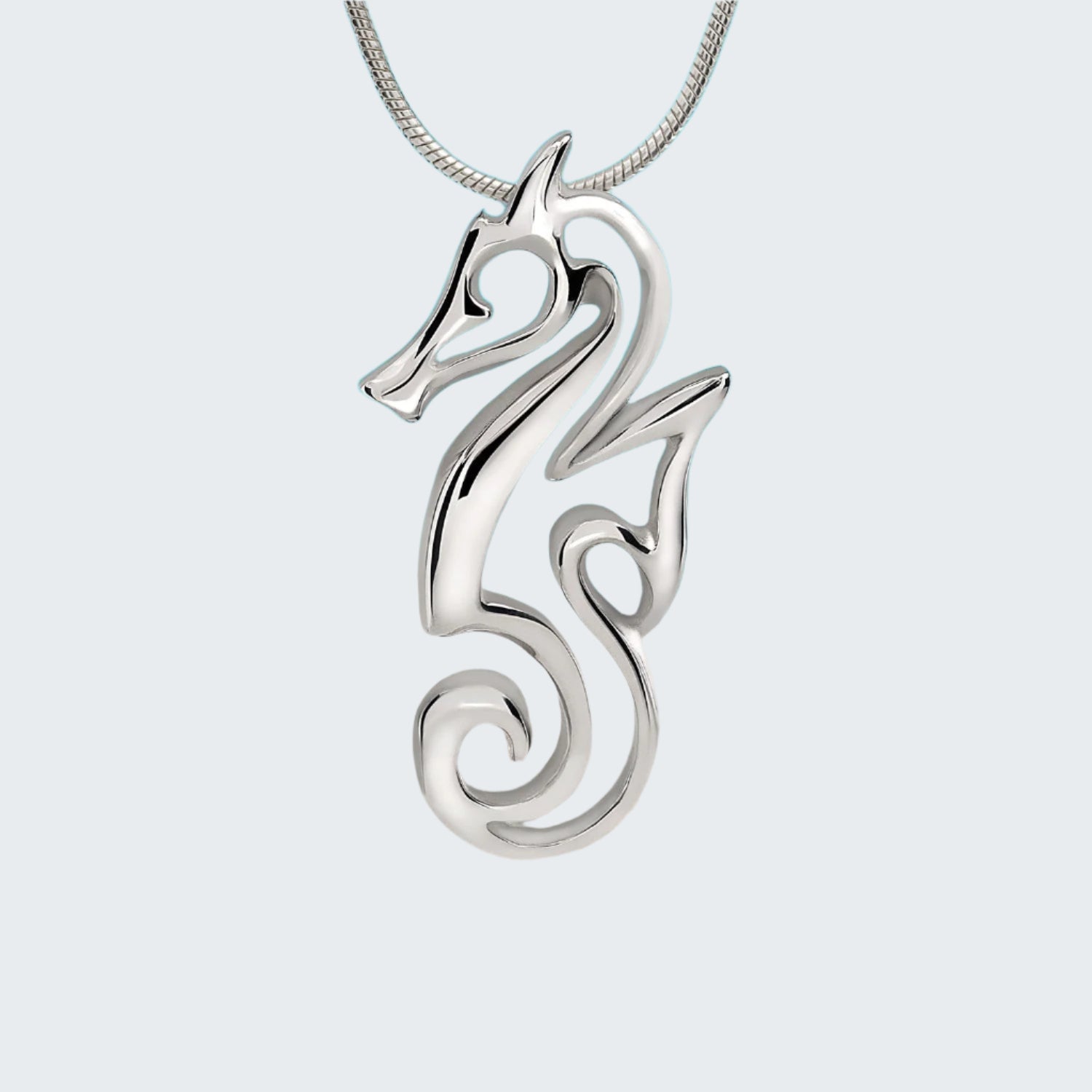 Silver seahorse pendant on a chain with a beach and ocean background