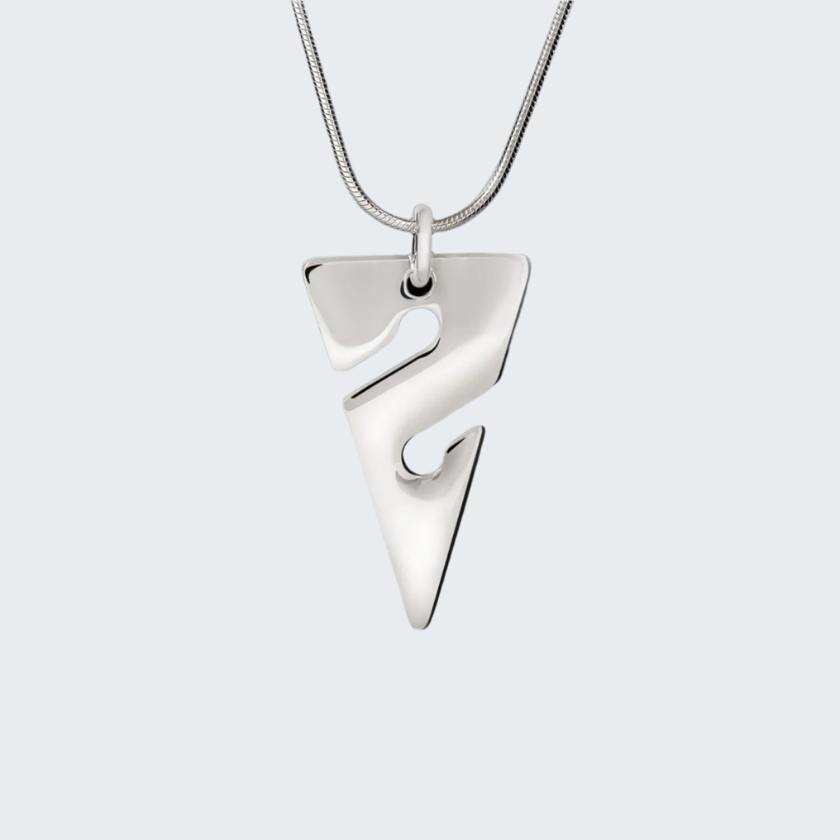 Silver pendant necklace on a reflective surface with a dark background