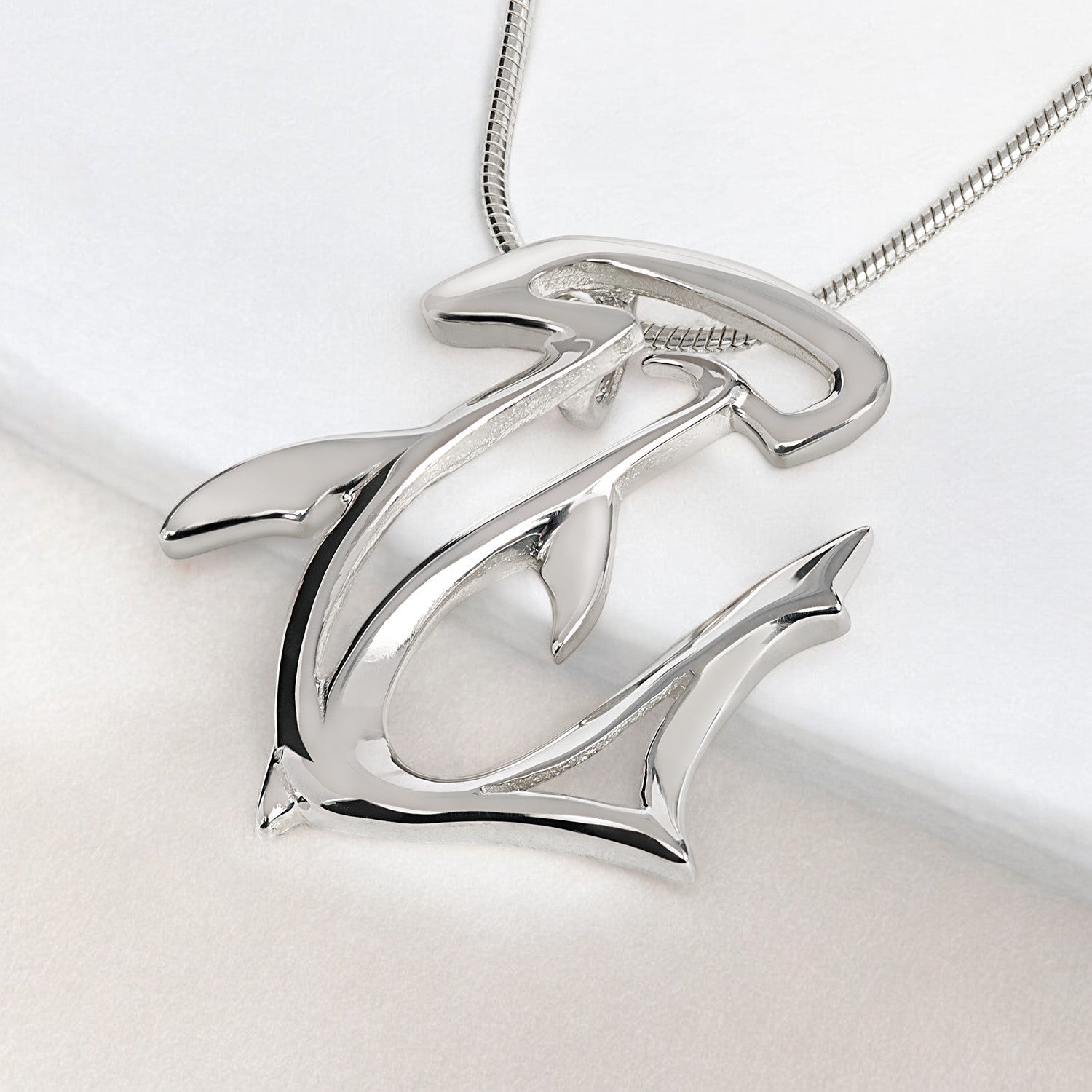 Silver pendant with a unique design on a light gray background