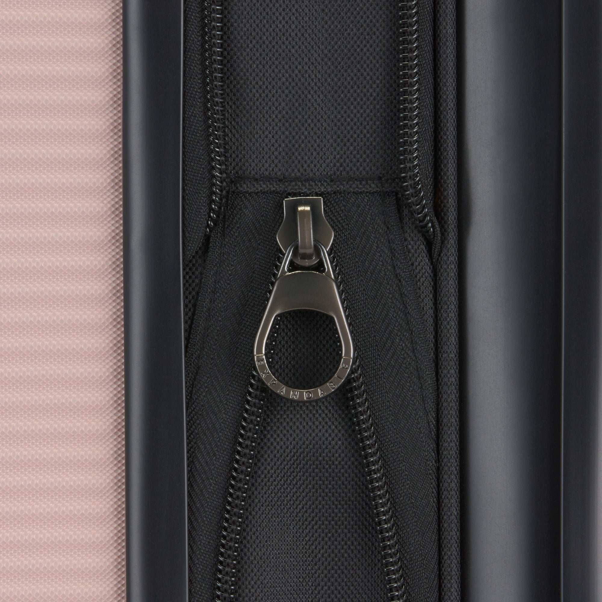 Close-up of a zipper on a suitcase with a pink and black design.