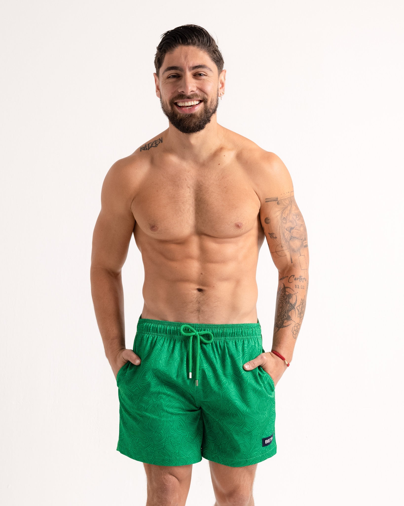Man wearing green swim shorts on a white background