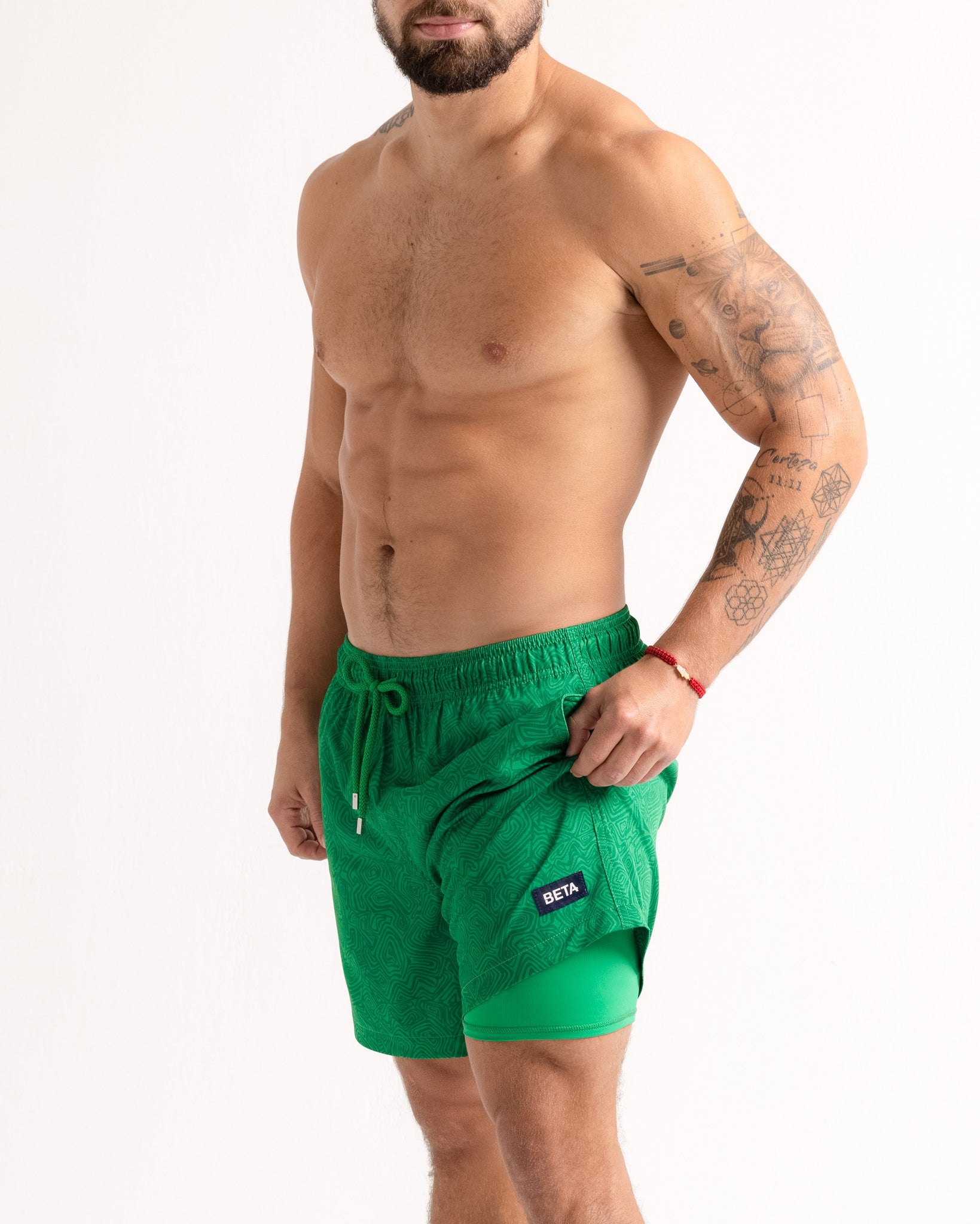 Man wearing green swim shorts on a white background