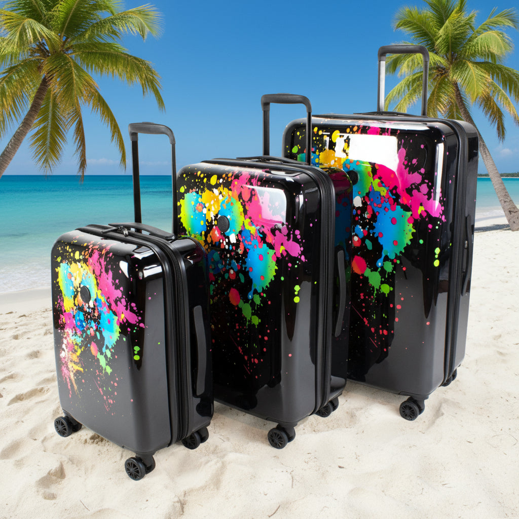 Set of three black suitcases with colorful splatter designs on a white background