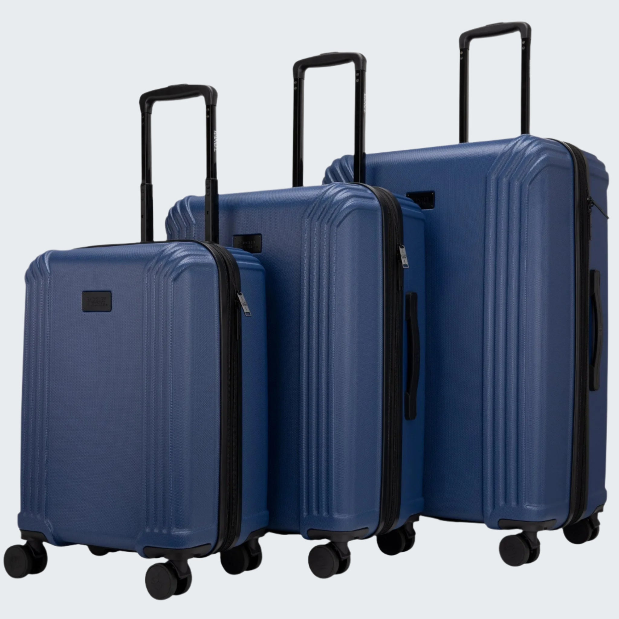 Set of three blue suitcases of different sizes on a white background