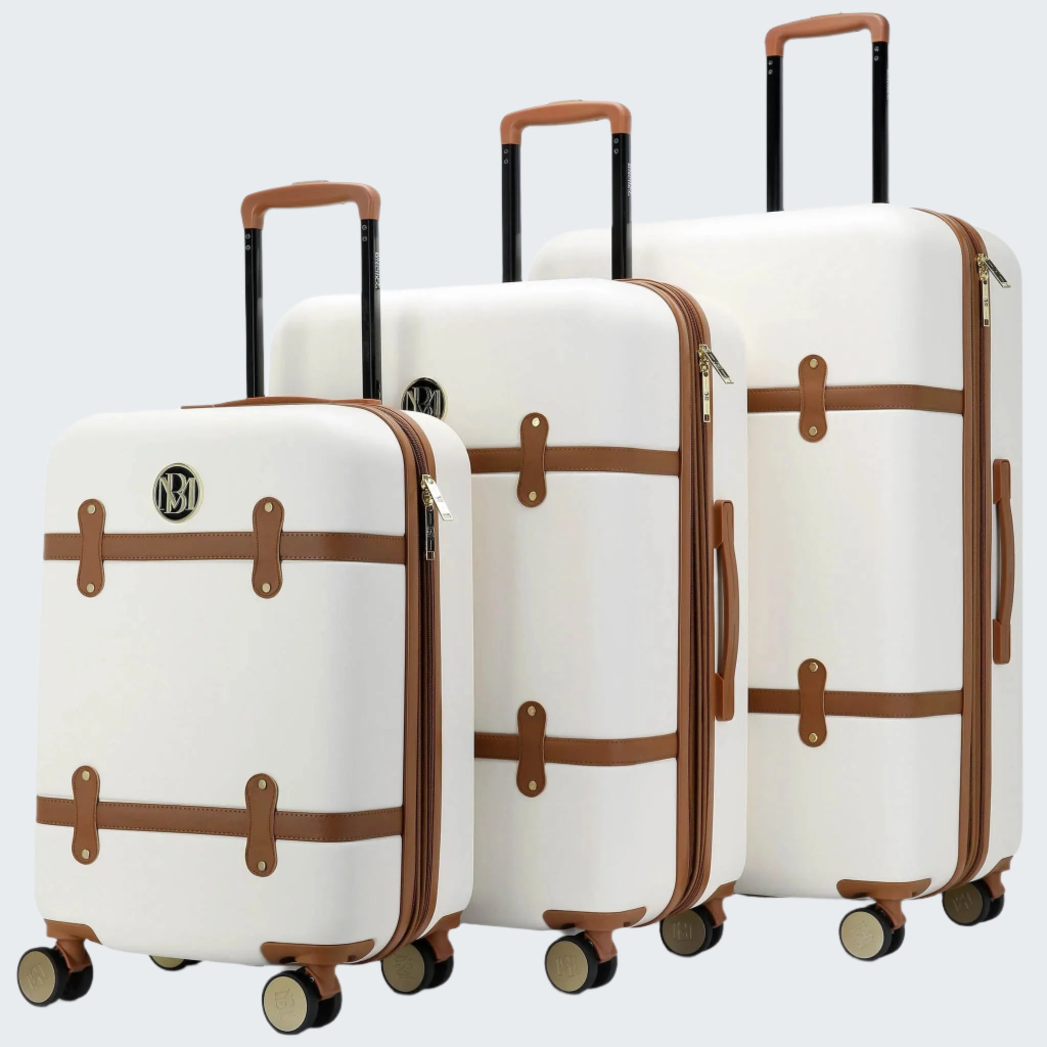 A set of three white retro-style expandable suitcases with vegan leather straps and metallic hardware, standing upright on four wheels.