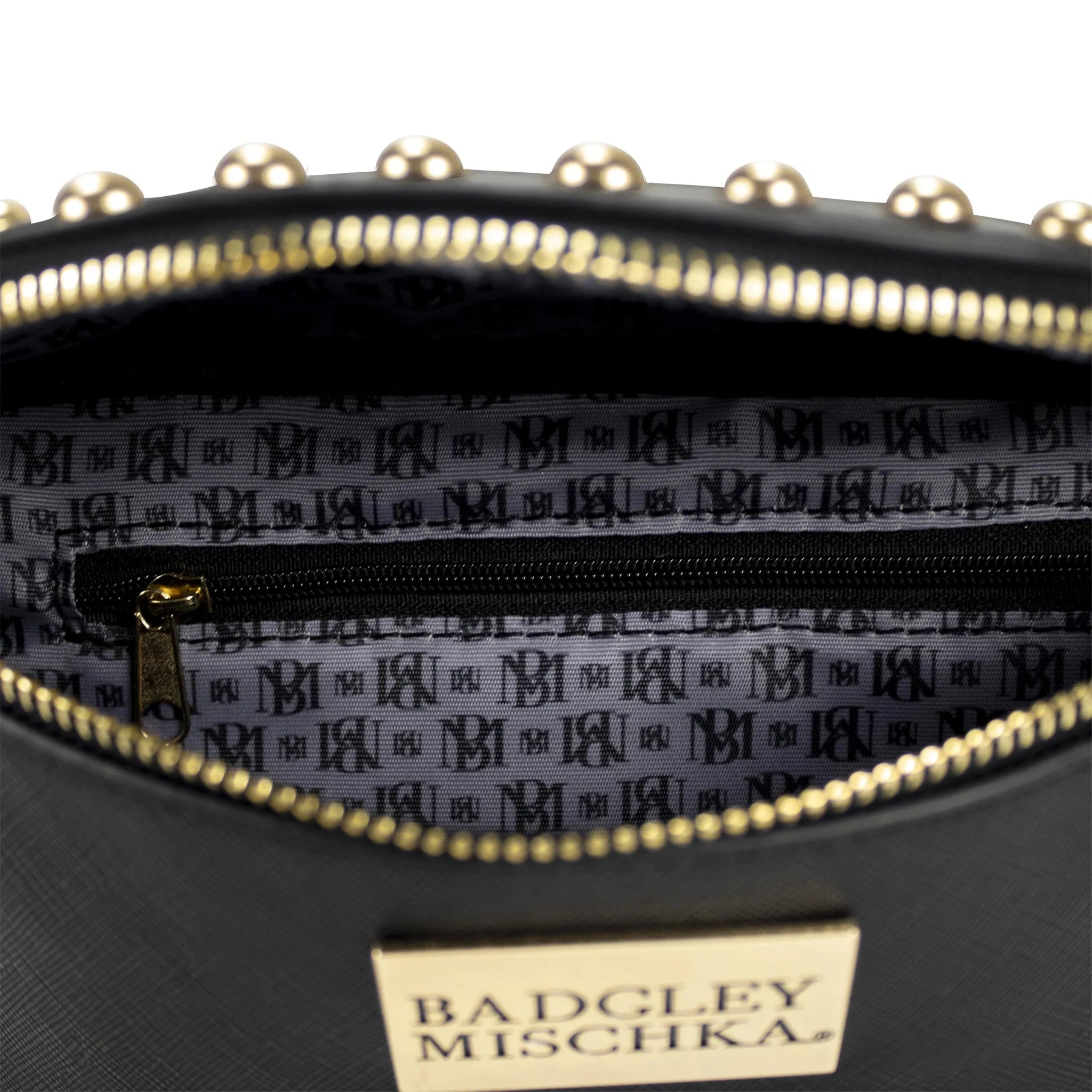 Close-up of a black handbag with gold accents and a visible brand label on a white background.