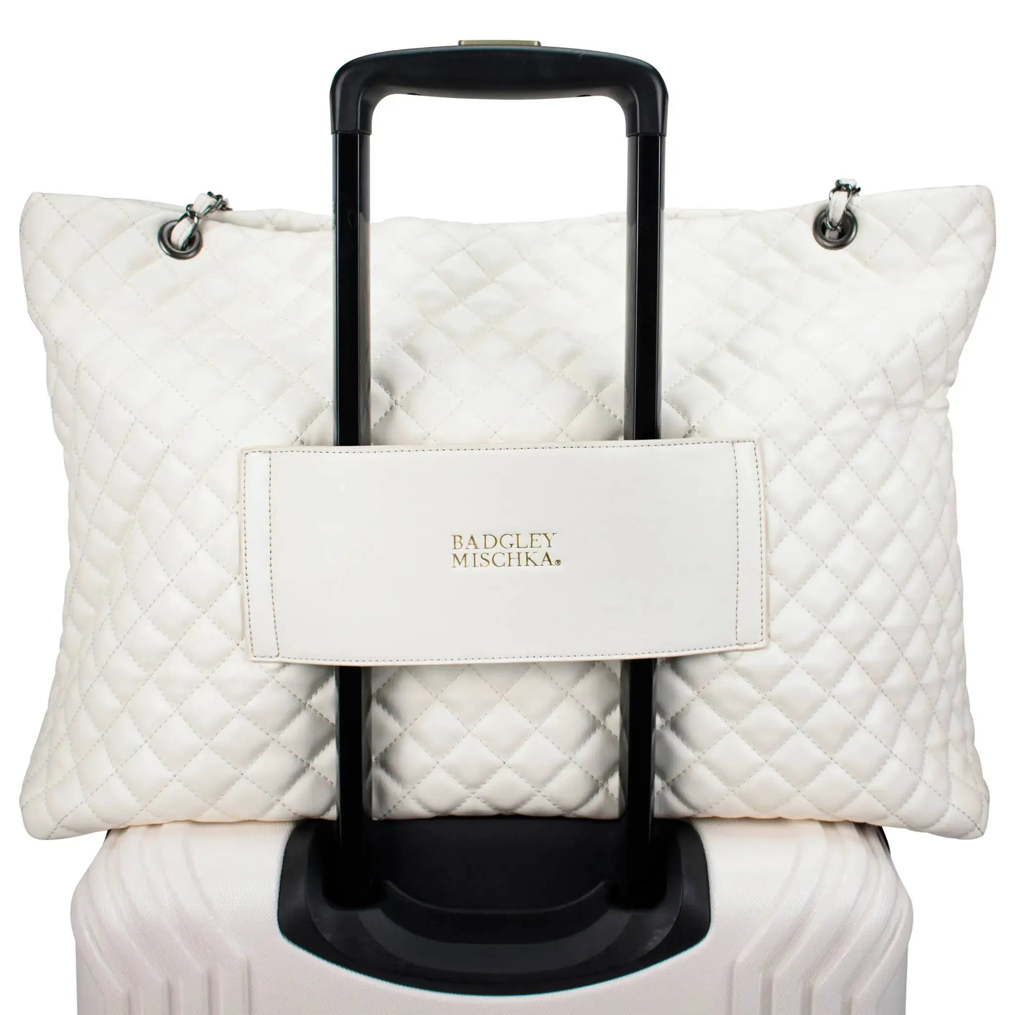 White quilted travel bag with a handle on a white background