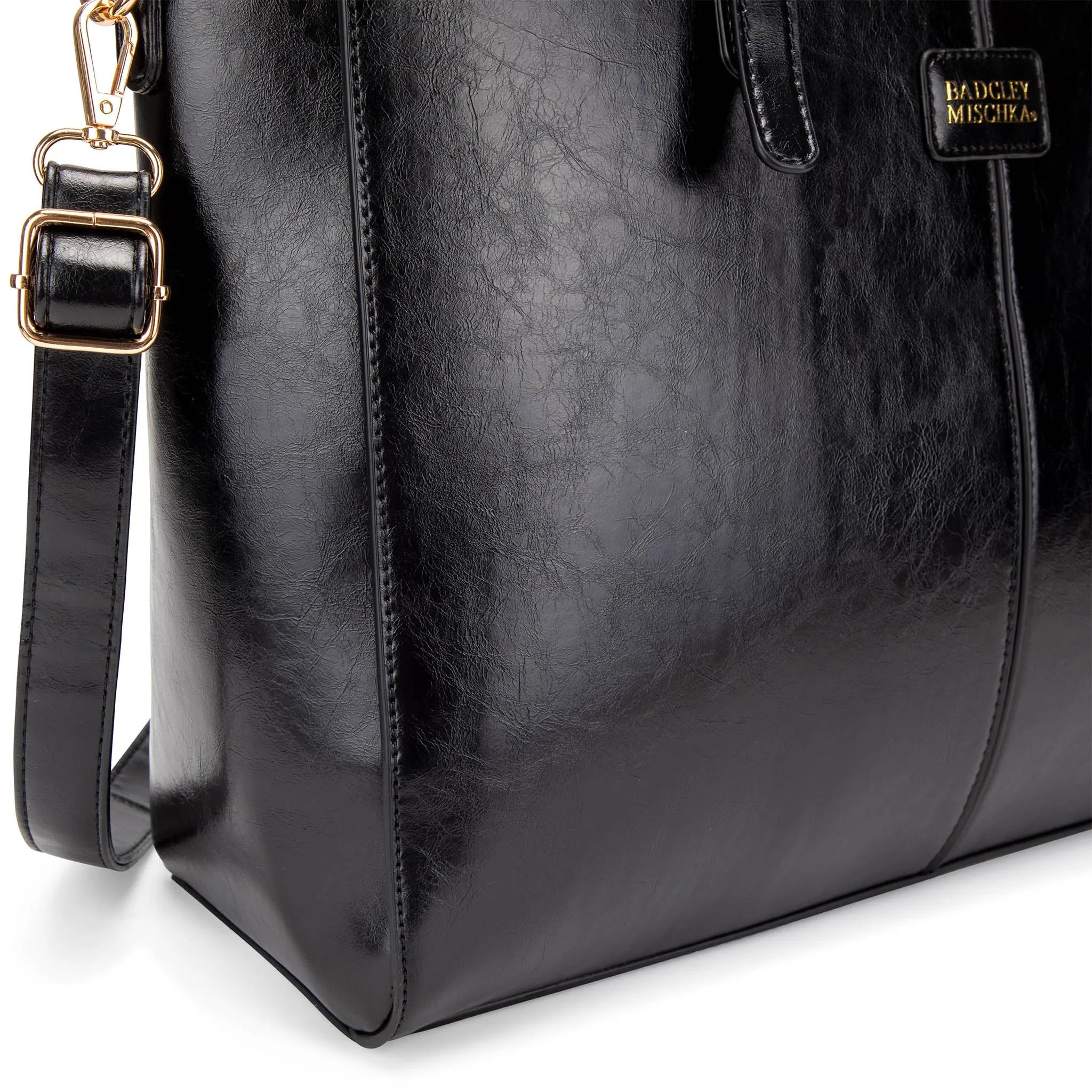 Black leather bag with gold hardware on a white background