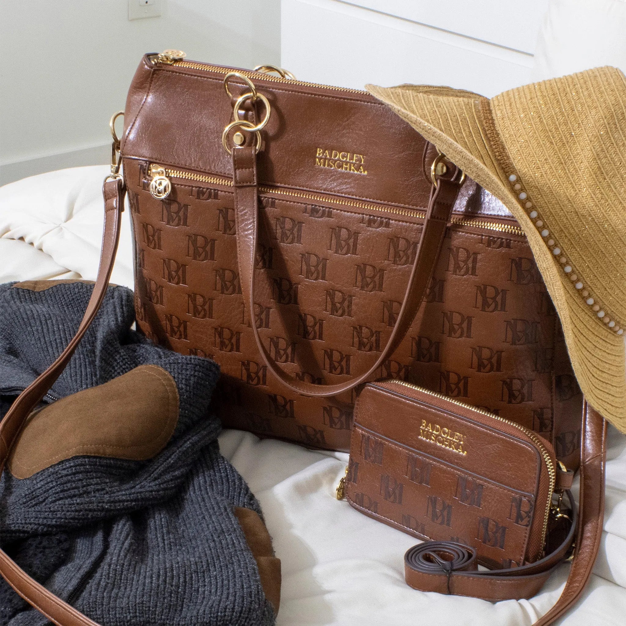 Brown handbag with gold accents and 'Badgley Mischka' branding on a white surface.