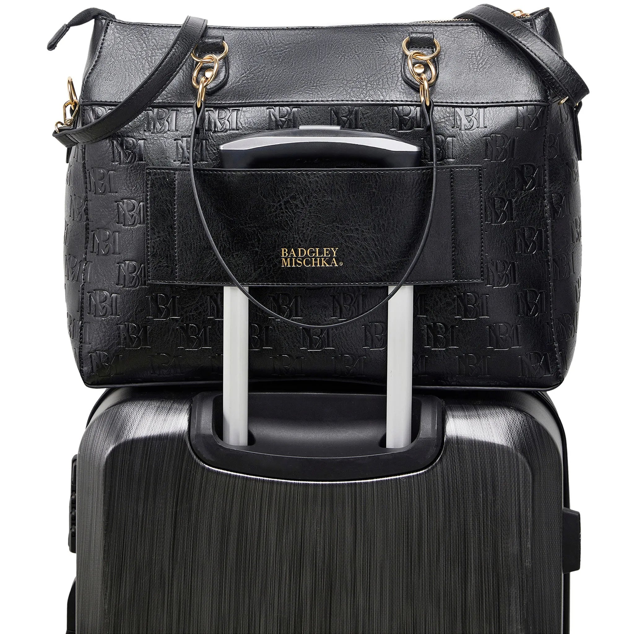 Black textured handbag with gold accents on top of a black suitcase, featuring the Badgley Mischka brand.
