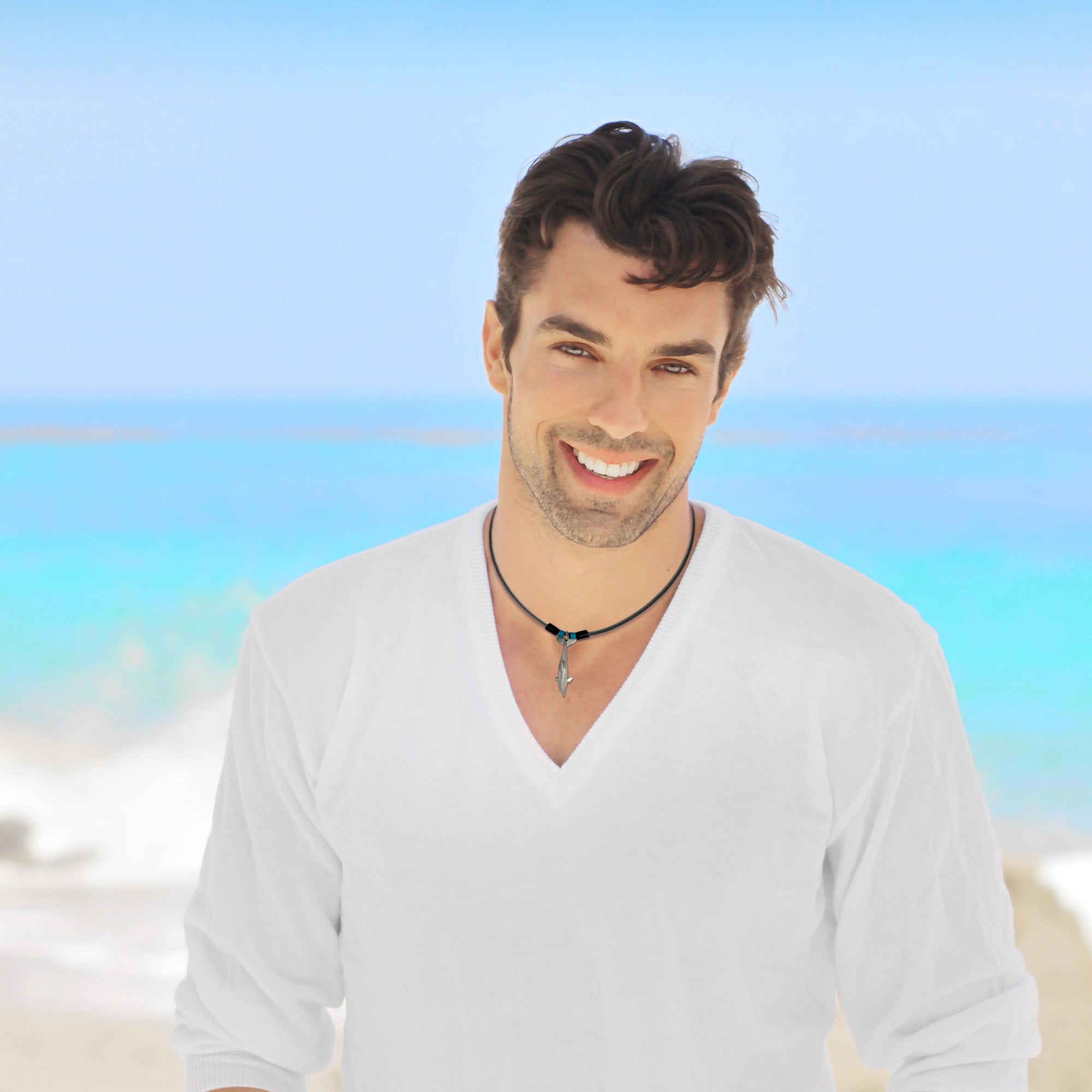 Man wearing a white shirt with a blurred beach background