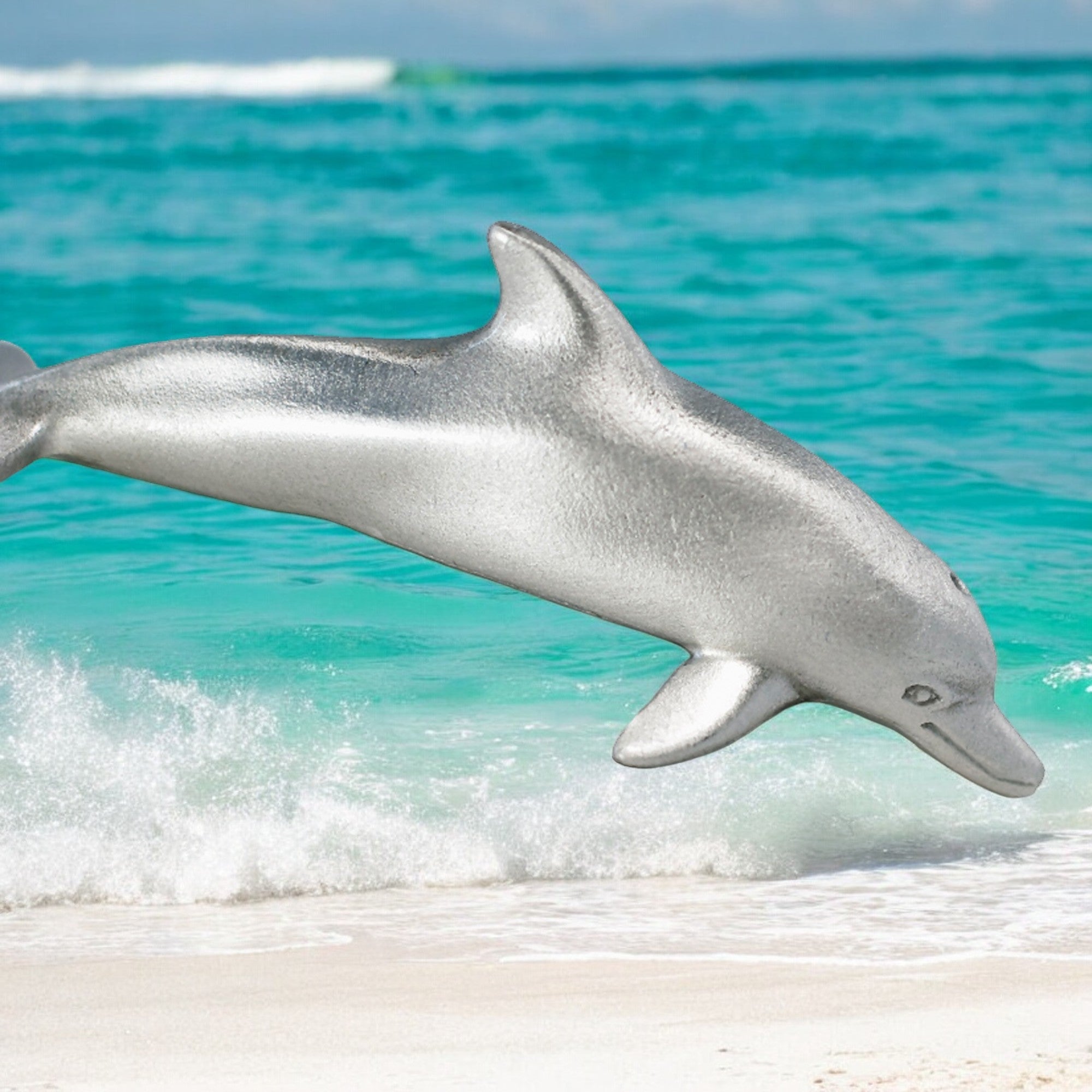 Dolphin leaping out of the water onto a sandy beach with turquoise ocean.