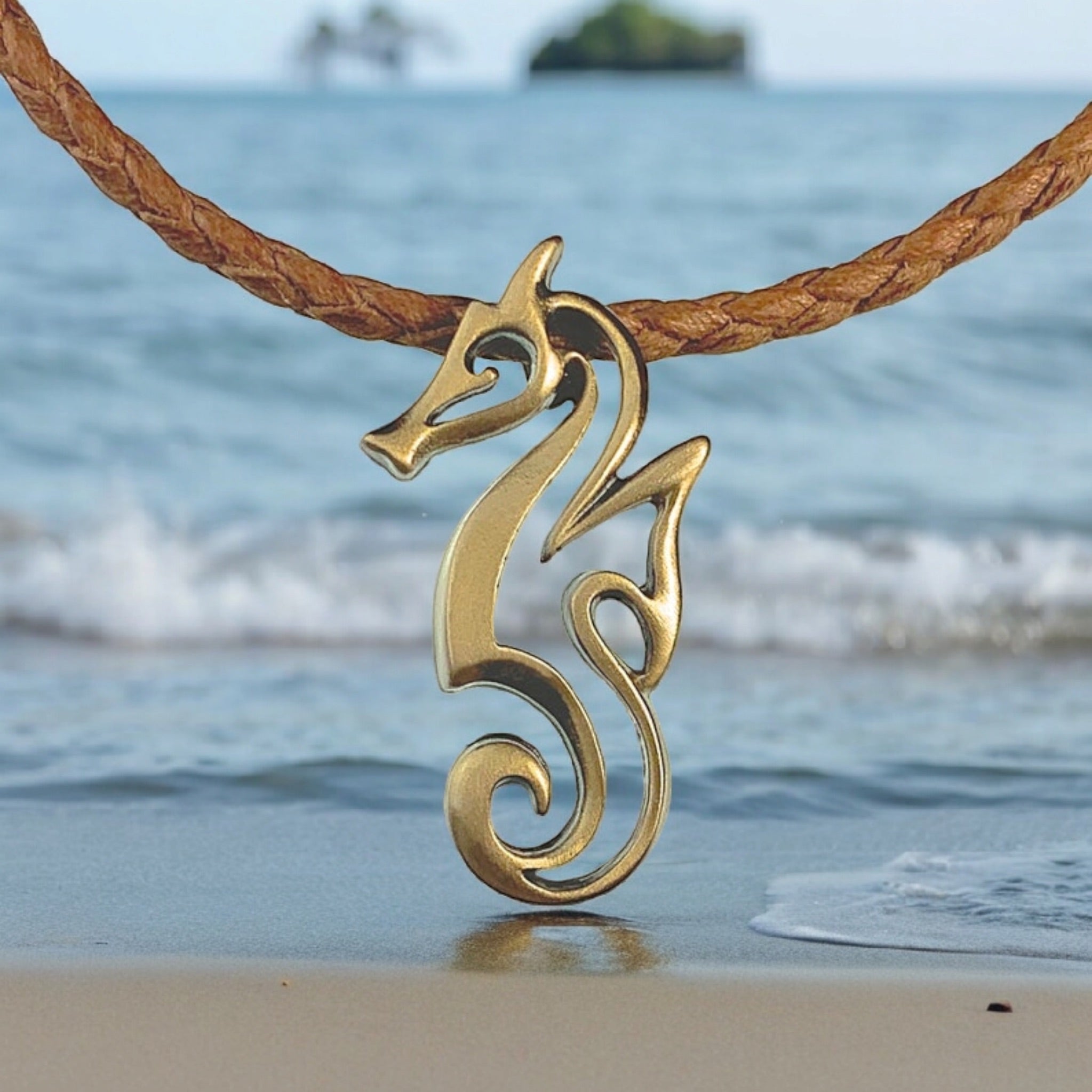 Gold seahorse pendant on a leather cord with a beach background