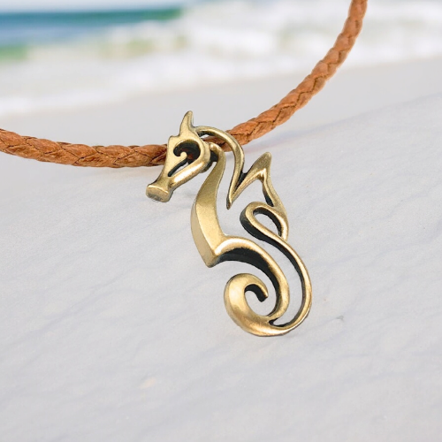 Brass-colored dragon-shaped pendant on a brown cord against a light background