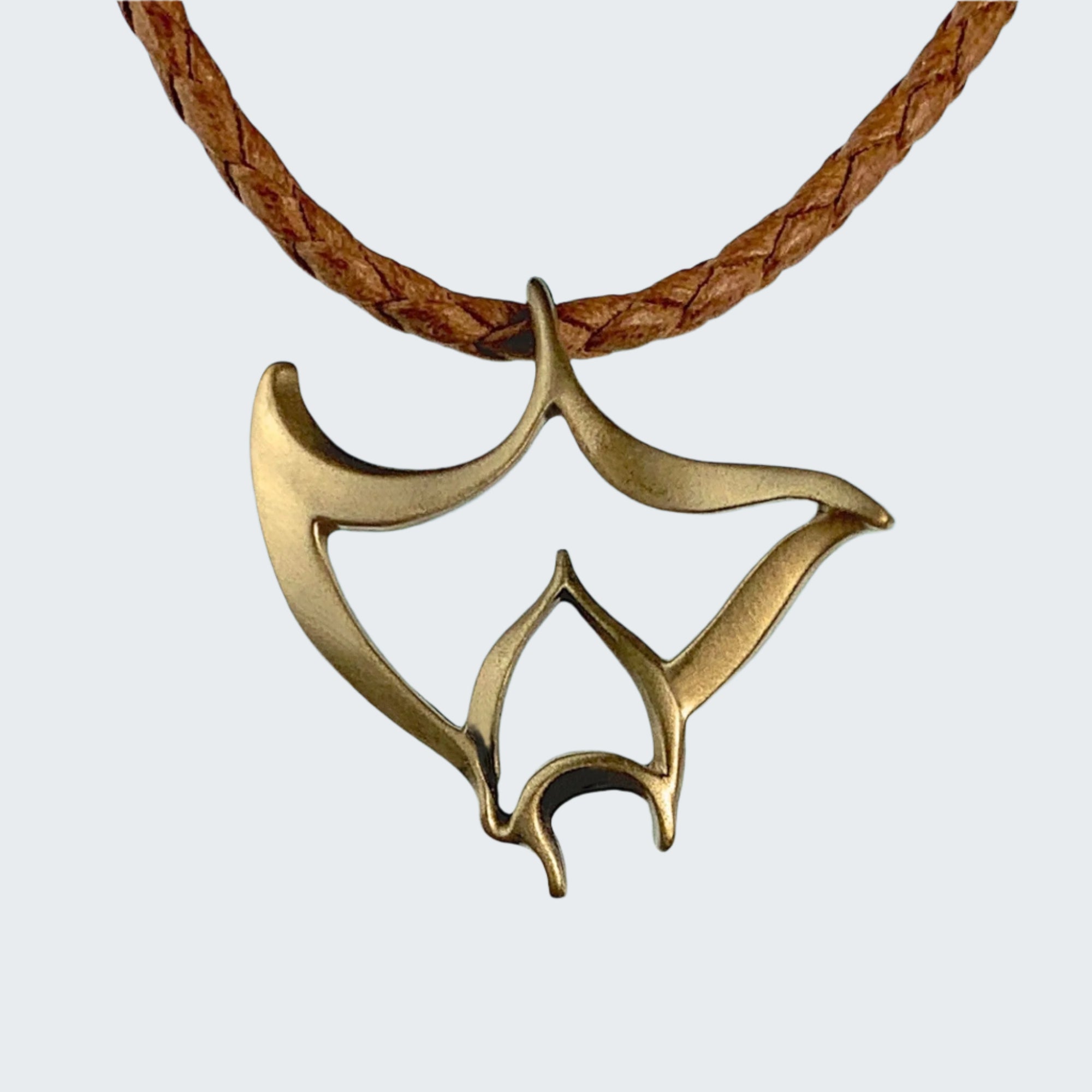 Bronze pendant on a leather cord with a beach background