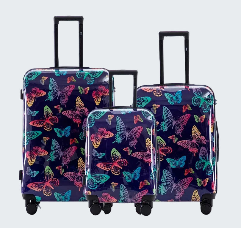 Set of three suitcases with colorful butterfly pattern on a white background