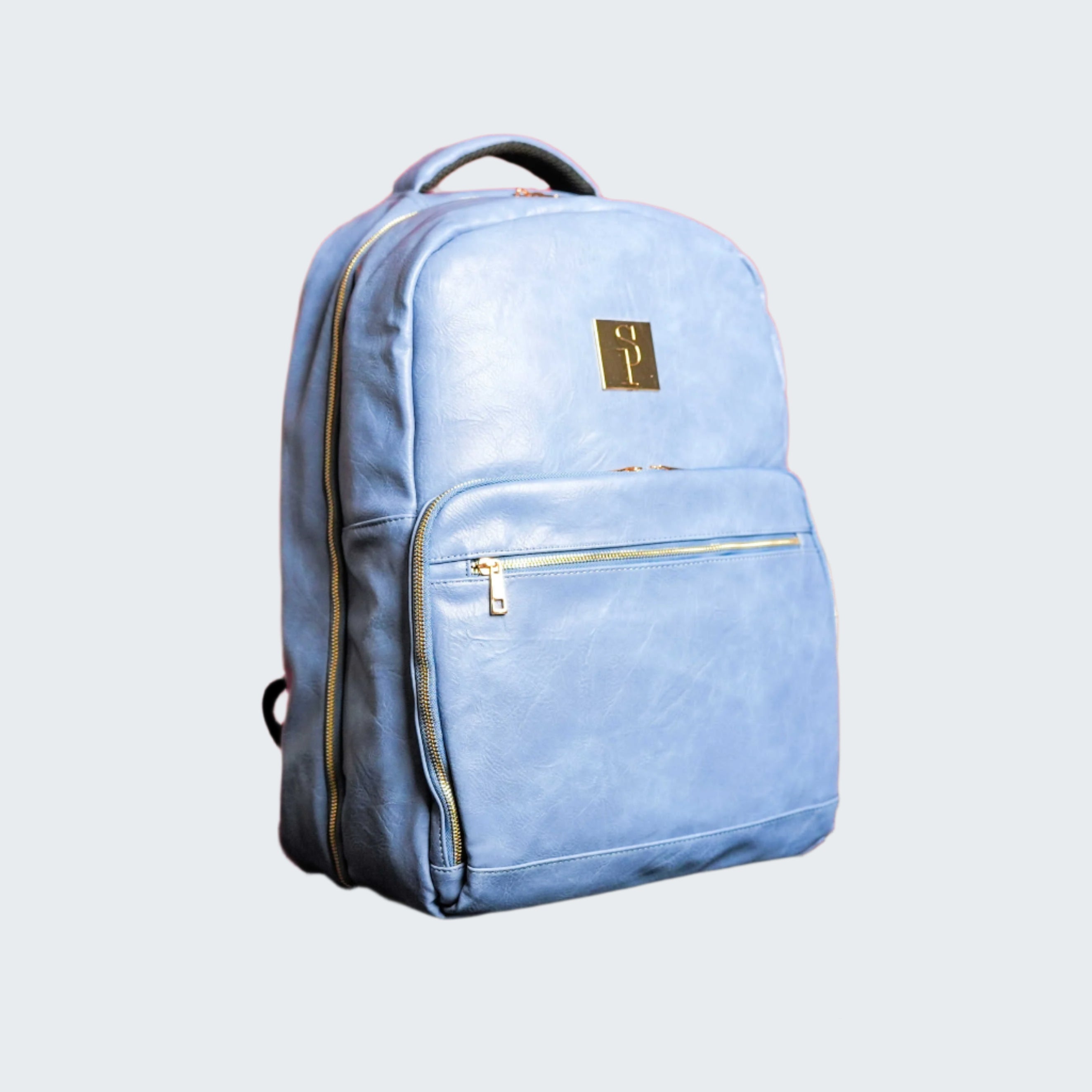 Light blue backpack with gold accents on a reflective surface with a red background