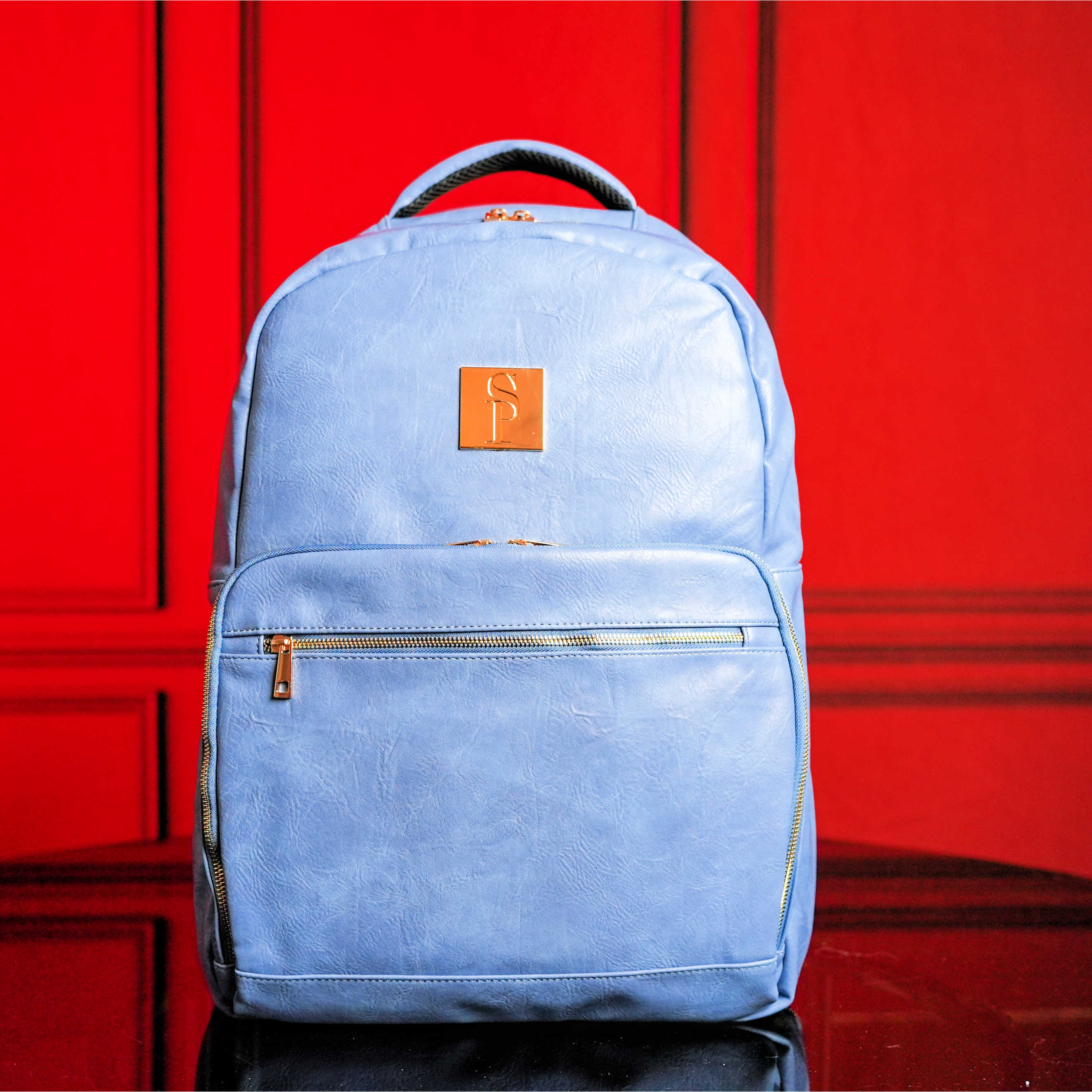 Blue backpack with an orange logo on a red background